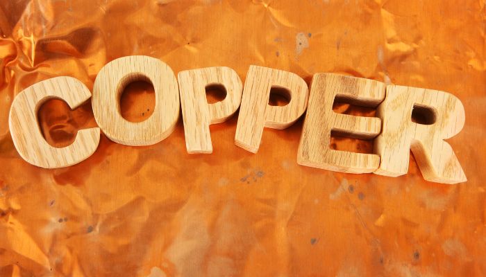 How to invest in copper. Copper word is written in wood letters in copper background